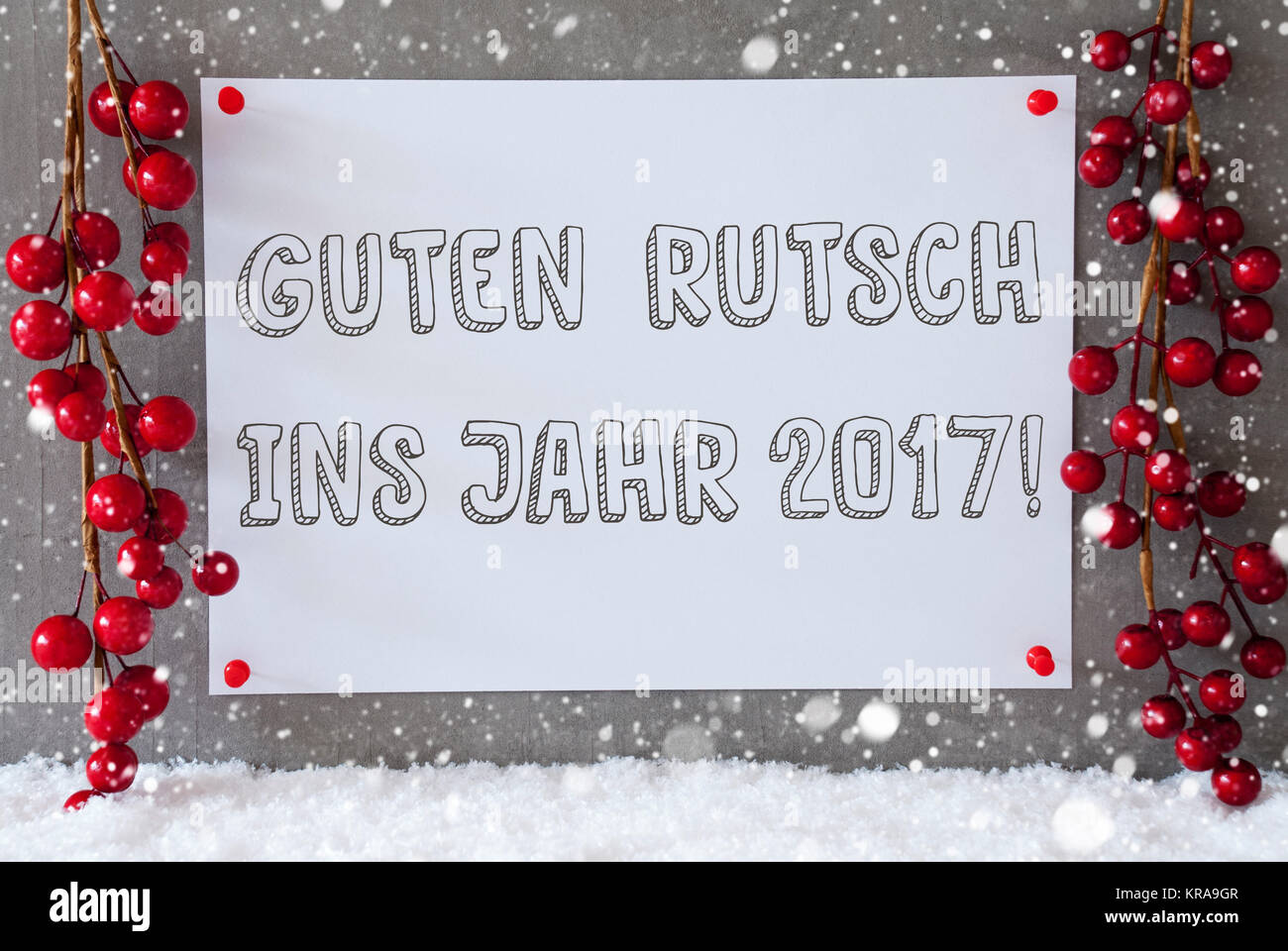 Label With German Text Guten Rutsch Ins Jahr 2017 Means New Year 2017. Red Christmas Decoration On Snow. Urban And Modern Cement Wall As Background With Snowflakes. Stock Photo