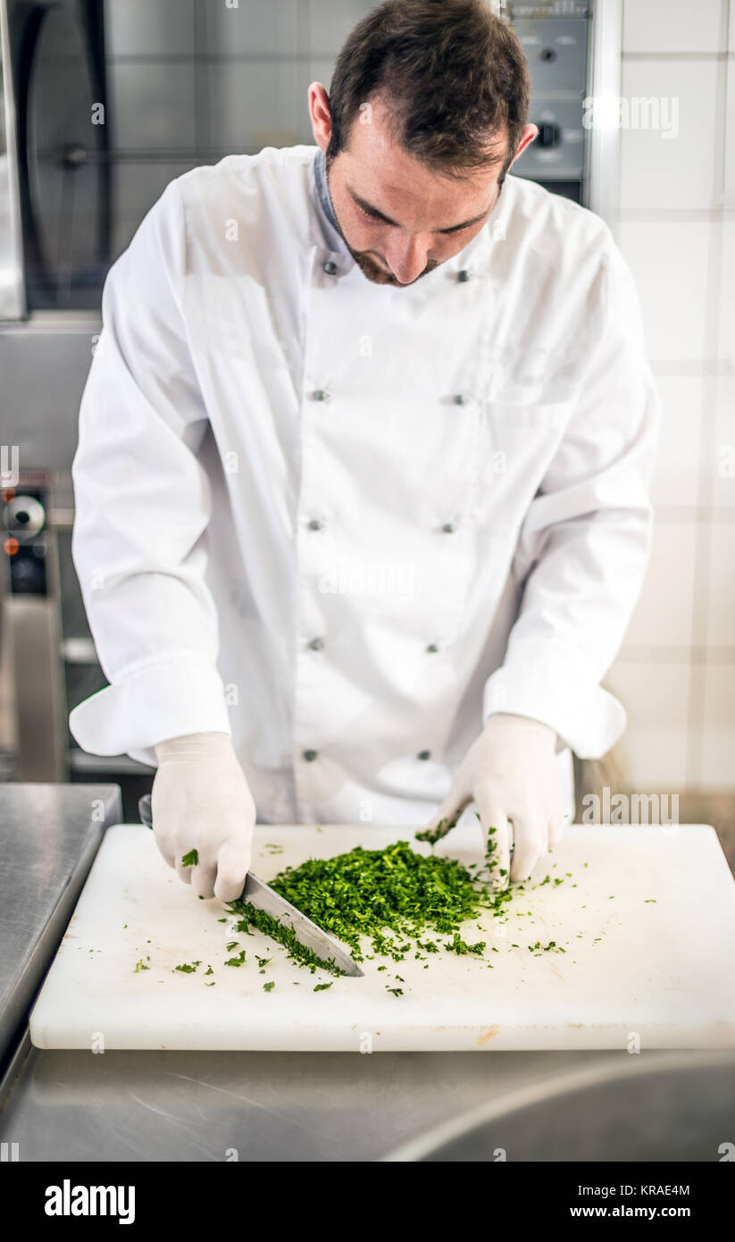 Premium Photo  Chef chopping parsley with knife on a wooden board close up