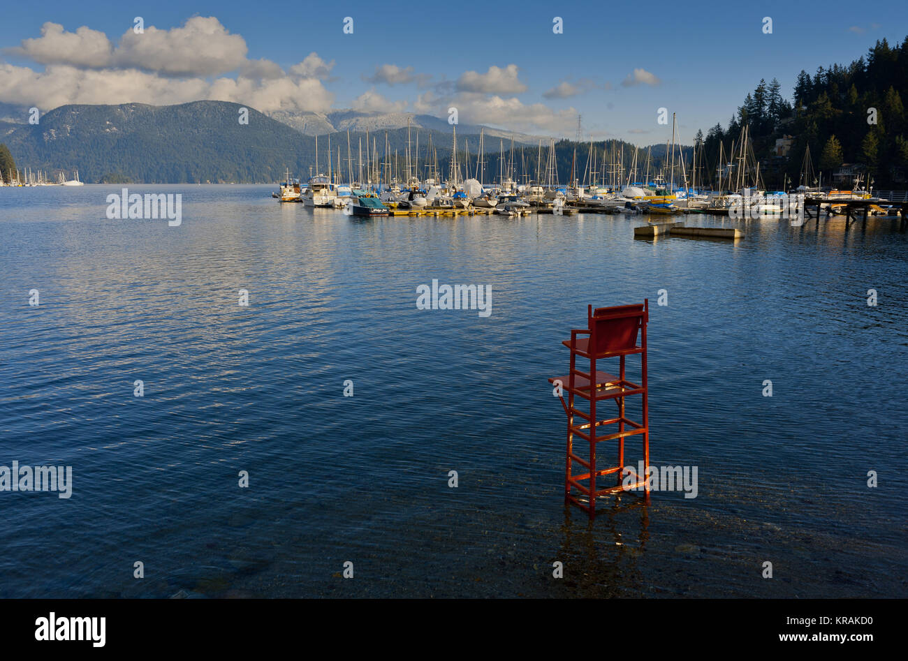A red lifeguard chair stands in the water at Deep Cove, North Vancouver, Canada. Stock Photo
