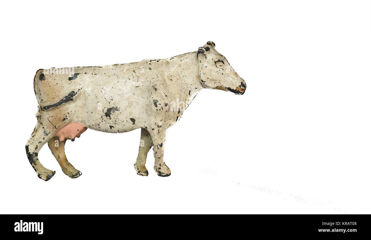 An old, weathered cast lead figure of a toy cow. Stock Photo
