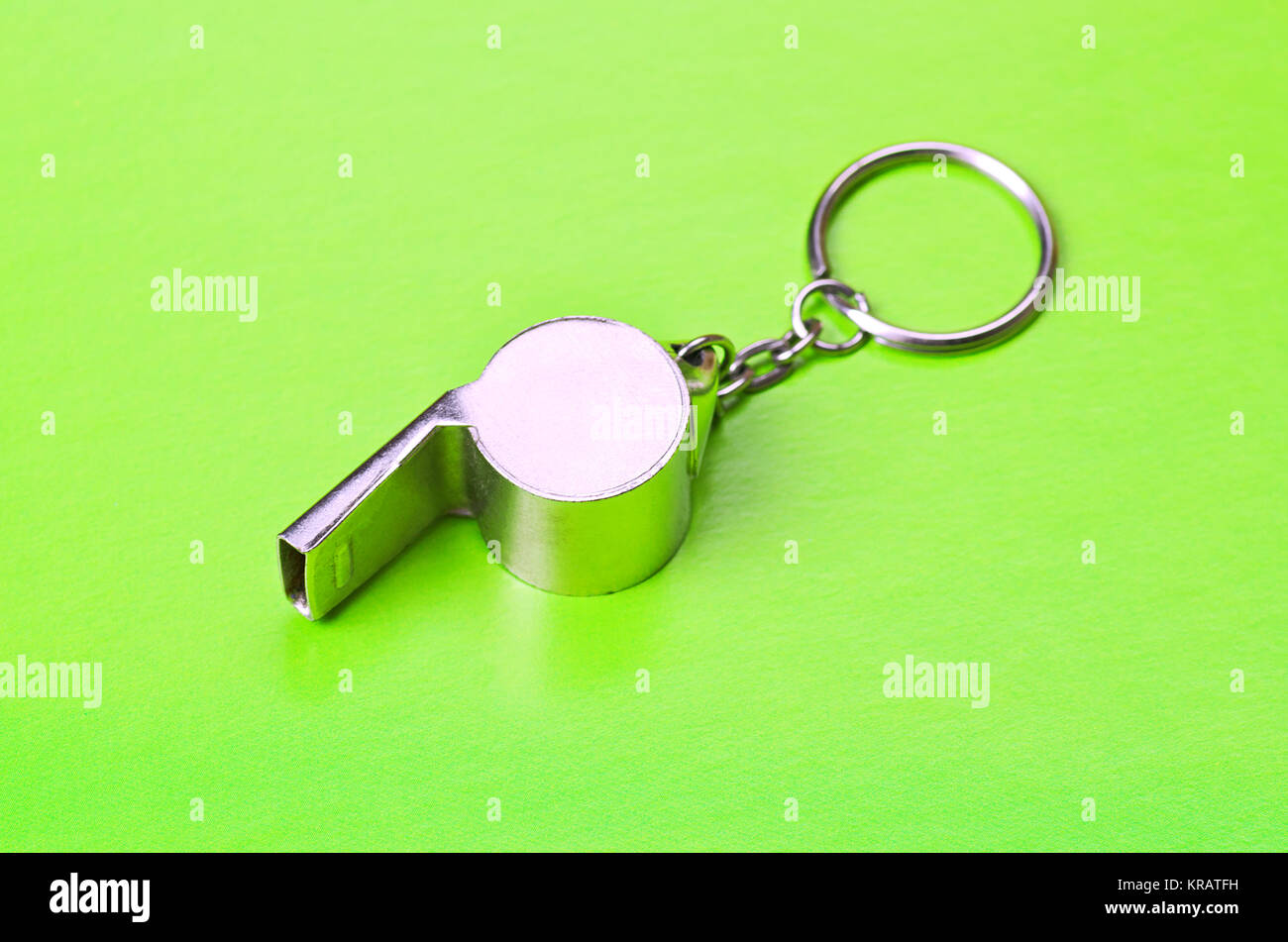 Sports or coaches metal whistle, closeup. Concept refereeing sport on green card background. Soccer or football referee whistle and caution cards Stock Photo