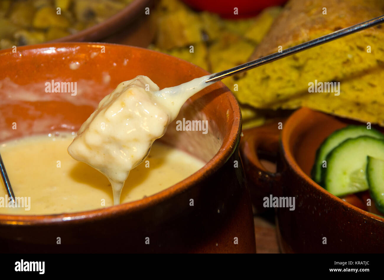 Bread dipping in a melted cheese fondue Stock Photo Alamy