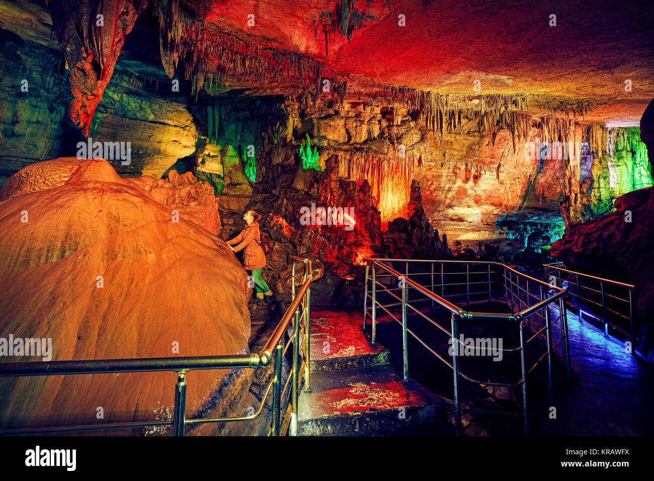 Tourist woman in underground cave Sataplia with colorful illumination in Kutaisi, Georgia Stock Photo