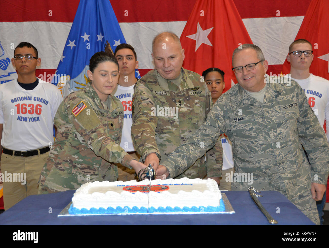 Maj. Gen. Raymond Shields, commander of the New York Army National Guard (middle) joins Air National Guard Chief Master Sgt. Michael Blake, age 58 the oldest  National Guard members present (right) and Army National Guard Spec. Jade Richards, age 19, one of the youngest members of the New York National Guard in cutting a cake in celebration of the National Guard’s 381th birthday at New York National Guard headquarters  in Latham, N.Y. on December, 13 2017. The National Guard was established in 1636 and is the oldest military force in the Department of Defense.  (U.S. Army National Guard Stock Photo