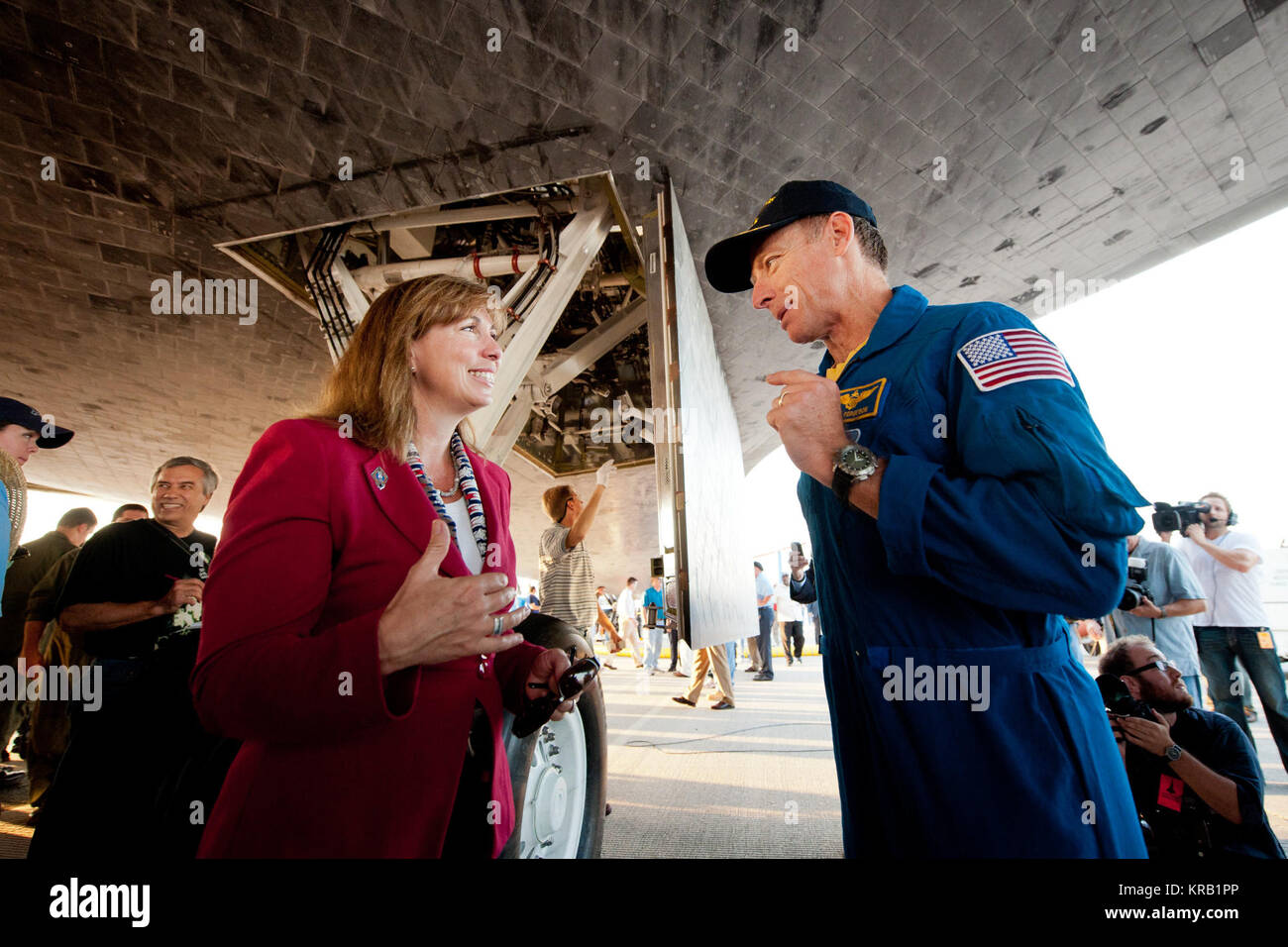 NASA Deputy Administrator Lori Garver and Commander Chris Ferguson talk underneath the space shuttle Atlantis shortly after Ferguson and the rest of the STS-135 crew landed at NASA's Kennedy Space Center Shuttle Landing Facility (SLF), completing its 13-day mission to the International Space Station (ISS) and the final flight of the Space Shuttle Program, early Thursday morning, July 21, 2011, in Cape Canaveral, Fla. Overall, Atlantis spent 307 days in space and traveled nearly 126 million miles during its 33 flights. Atlantis, the fourth orbiter built, launched on its first mission on Oct. 3, Stock Photo