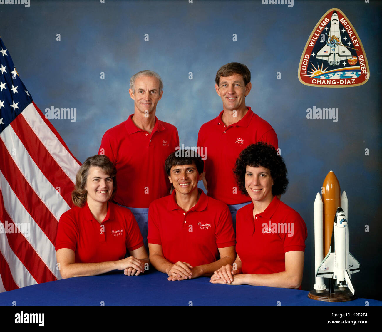 STS-34 Atlantis, OV-104, official crew portrait includes Commander Donald E. Williams, Pilot Michael J. McCulley, Mission Specialist (MS) Shannon W. Lucid, MS Ellen S. Baker, and MS Franklin R. Chang-Diaz wearing red mission t-shirts. Seated (left to right) are Lucid, Chang-Diaz, and Baker with Williams (left) and McCulley standing. Crew patch or emblem is displayed in the background. Sts-34 crew Stock Photo