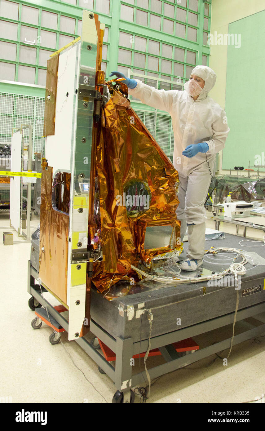 Aleksandra Bogunovic reaches across the instrument to affix the corners of a Multi-Layer Insulation blanket to the TIRS instrument.  The Thermal Infrared Sensor (TIRS) will fly on the next Landsat satellite, the Landsat Data Continuity Mission (LDCM).  TIRS was built on an accelerated schedule at NASA's Goddard Space Flight Center, Greenbelt, Md. and will now be integrated into the LDCM spacecraft at Orbital Science Corp. in Gilbert, Ariz.   The Landsat Program is a series of Earth observing satellite missions jointly managed by NASA and the U.S. Geological Survey. Landsat satellites have been Stock Photo