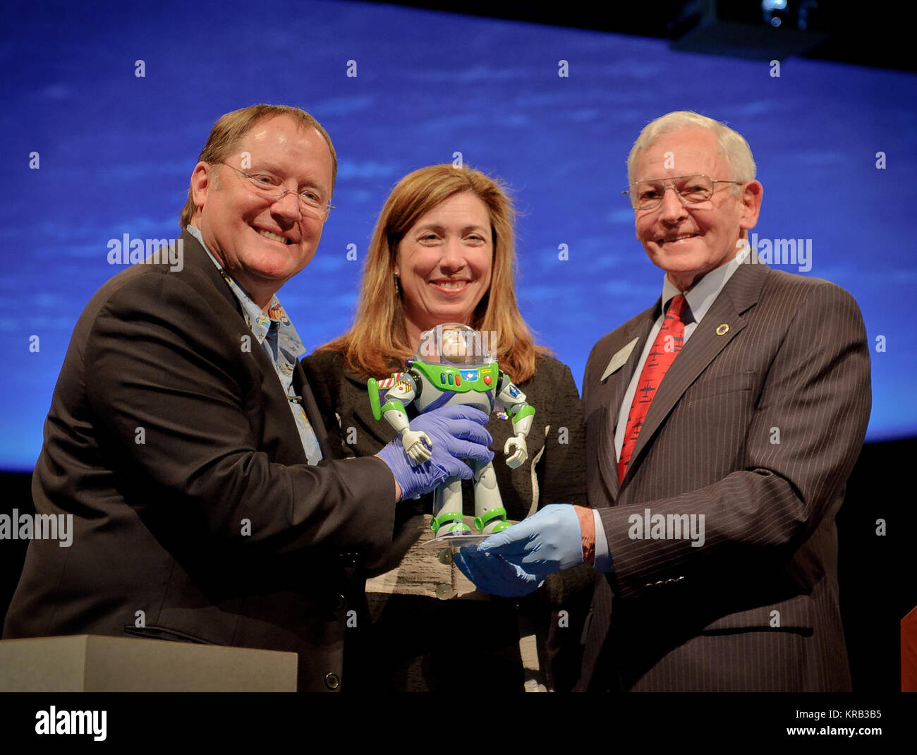 John Lasseter, Director of the film 'Toy Story', left, NASA Deputy Administrator Lori Garver, and Gen. J.R. 'Jack' Dailey, right, hold Buzz Lightyear of the film at the Smithsonian National Air and Space Museum's Moving Beyond Earth Gallery, Thursday, March 29, 2012, in Washington. Launched May 31, 2008 aboard the space shuttle Discovery (STS-124) and returned on Discovery 15 months later with STS-128, the 12-inch action figure is the longest serving toy in space and became part of the museum's popular culture collection. Photo Credit: (NASA/Paul E. Alers) John Lasseter, Lori Garver, J.R. 22Ja Stock Photo