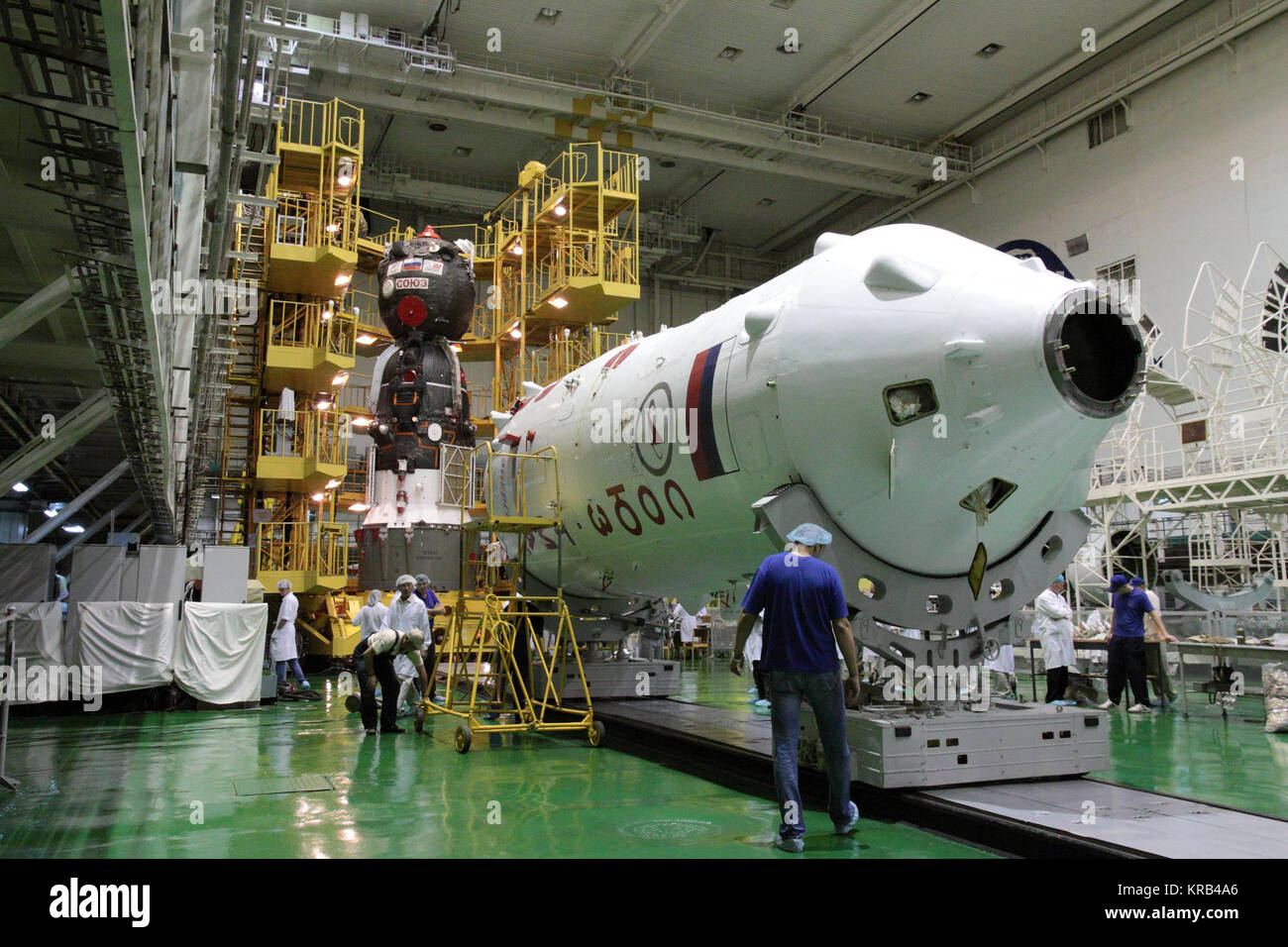 With the upper stage of the Soyuz booster in the foreground and the Soyuz TMA-05M spacecraft in the background, technicians at the Baikonur Cosmodrome in Kazakhstan prepared to encapsulate the Soyuz vehicle into its booster July 8, 2012, setting the stage for the launch of Expedition 32/33 Soyuz Commander Yuri Malenchenko, NASA Flight Engineer Sunita Williams and Flight Aki Hoshide of the Japan Exploration and Space Agency July 15 to the International Space Station for a four-month mission.  NASA/Victor Zelentsov Soyuz TMA-05M spacecraft integration facility 1 Stock Photo
