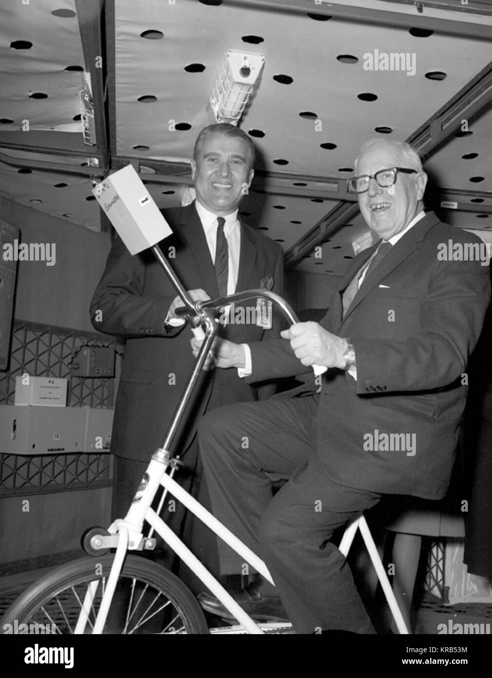 DURING A VISIT TO THE MARSHALL SPACE FLIGHT CENTER (MSFC), THE CONGRESSIONAL HOUSE COMMITTEE ON SCIENCE AND ASTRONAUTICS TOURED THE S-IVB WORKSHOP.  PICTURED HERE ARE MSFC'S DR WERHNER VON BRAUN (STANDING) AND CONGRESSMAN MILLER, A DEMOCRATIC REPRESENTATIVE OF CALIFORNIA (SITTING ON THE ERGOMETER BICYCLE) INSIDE THE WORKSHOP. VonBraunMiller Stock Photo