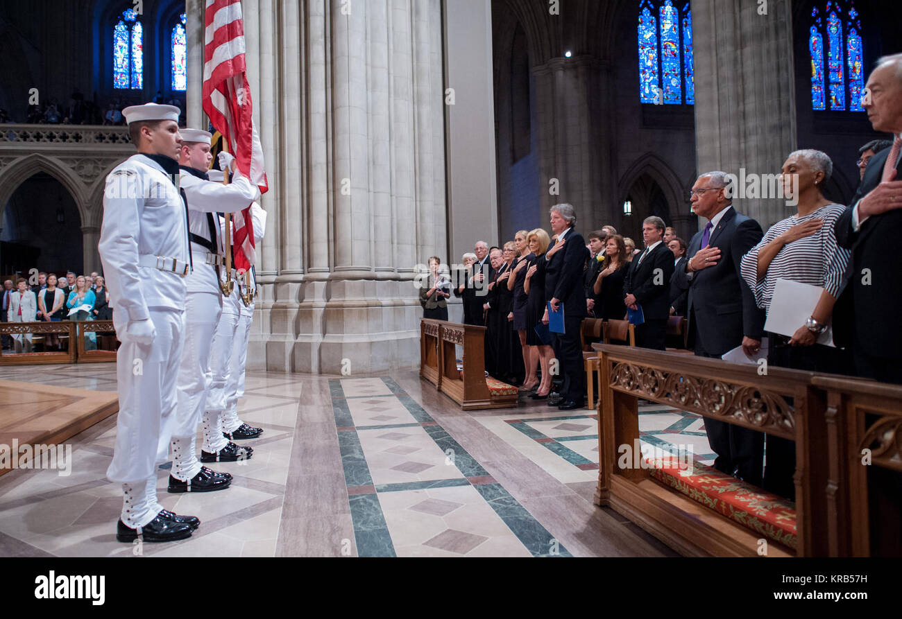 Attendees including from right, John Dalton, Jackie Bolden, Charles Bolden along with the family members of Neil Armstrong on the opposite row stands with their hands over their hearts as a U.S. Navy ceremonial guard stands with the colors at the start of a memorial service celebrating the life of Neil Armstrong at the Washington National Cathedral, Thursday, Sept. 13, 2012. Armstrong, the first man to walk on the moon during the 1969 Apollo 11 mission, died Saturday, Aug. 25. He was 82. Photo Credit: (NASA/Bill Ingalls) Neil Armstrong public memorial service (201209130021HQ) Stock Photo