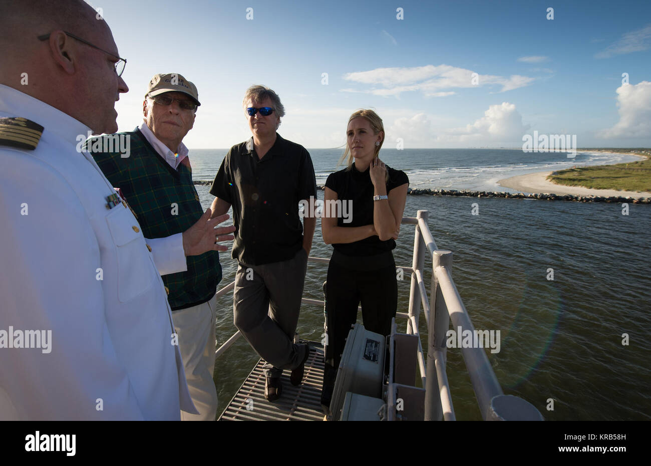 Navy Force Chaplain, Capt. Donald P. Troast, CHC, USN, left, talks with Dean Armstrong, brother of the late Neil Armstrong, Eric 'Rick' Armstrong, Neil Armstrong's son, center, and Molly Van Wagenen, Neil Armstrong's step-daughter, from the top of the USS Philippine Sea (CG 58) as it departs Mayport, Fla for the burial at sea service for Armstrong, Friday, Sept. 14, 2012, in the Atlantic Ocean. Armstrong, the first man to walk on the moon during the 1969 Apollo 11 mission, died Saturday, Aug. 25. He was 82. Photo Credit: (NASA/Bill Ingalls) Neil Armstrong burial at sea (201209140002HQ) Stock Photo