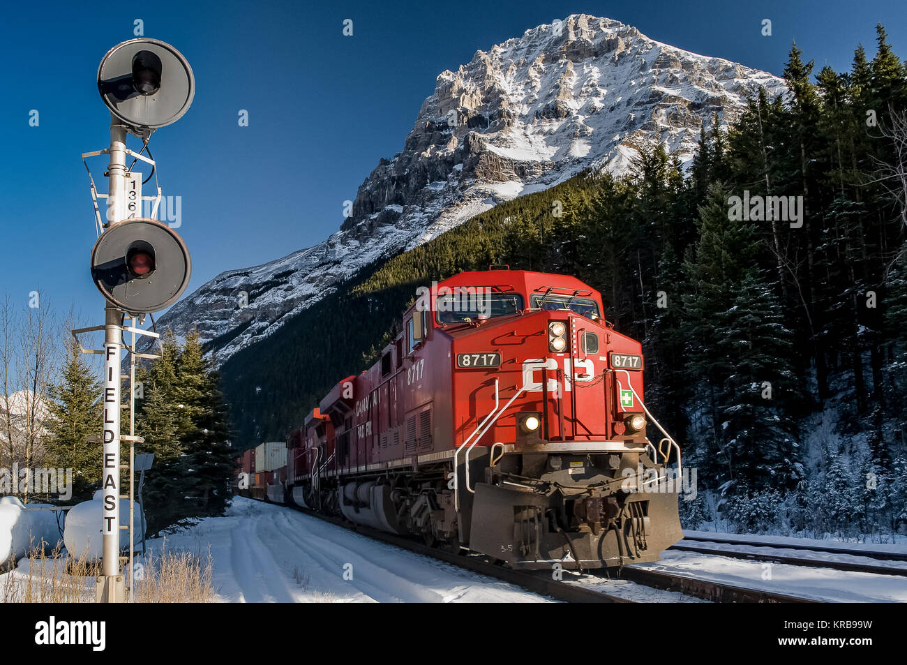 CP Rail intermodal freight westbound led by loco 8717 passes Field East signal Yoho National Park in winter Stock Photo