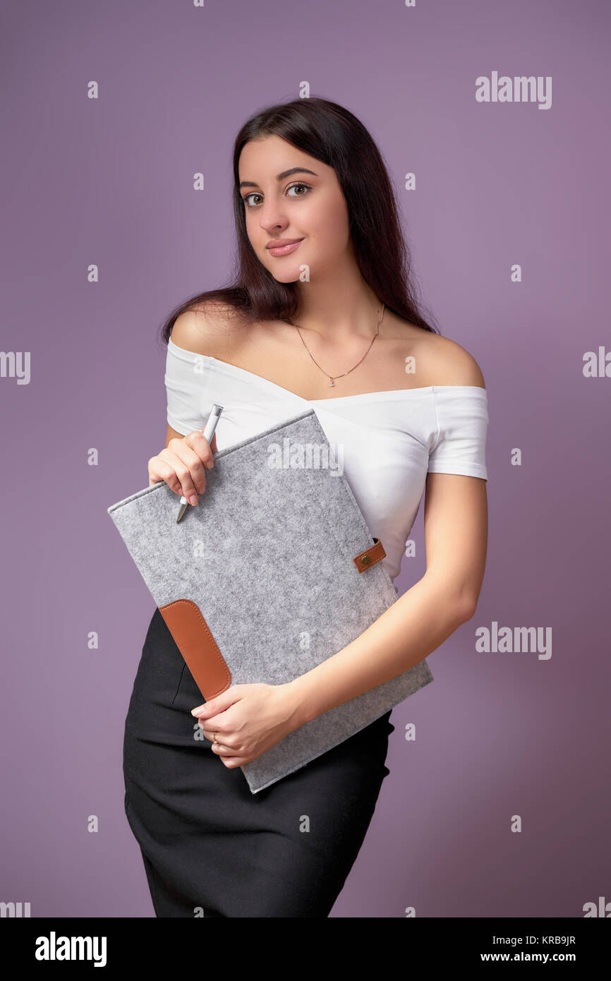 Young female model College student.girl posing with a folder in hands
