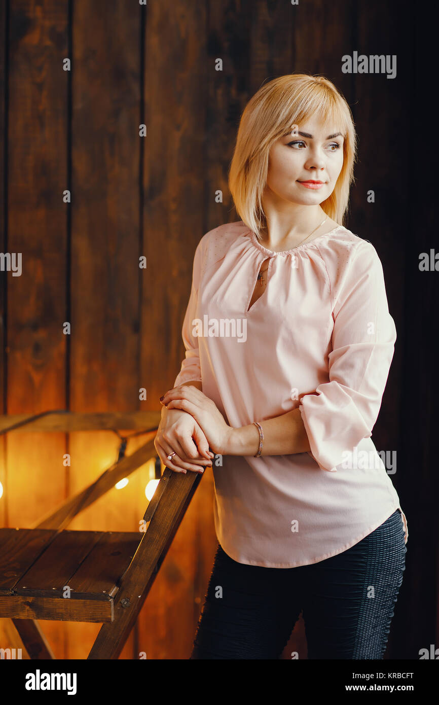 blonde girl sitting on a chair Stock Photo - Alamy