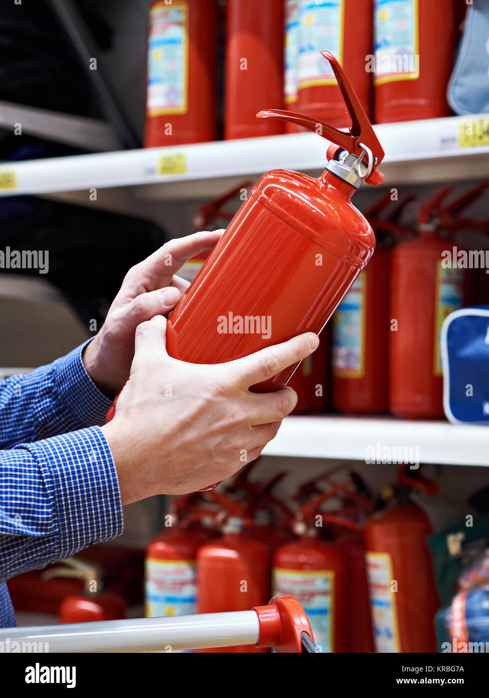 Buyer with fire extinguisher in hands at hardware store Stock Photo Alamy