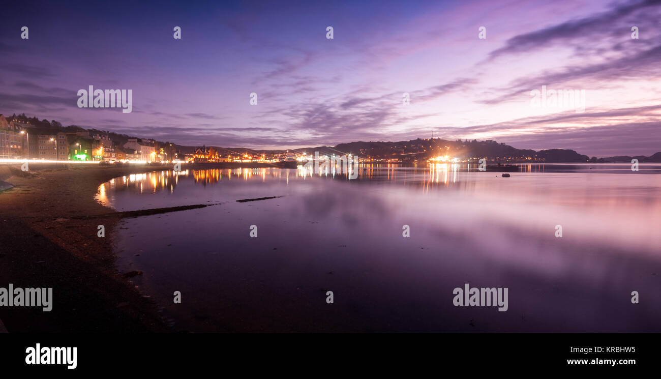 The lights of Oban town are reflected in the sea water along the sweep