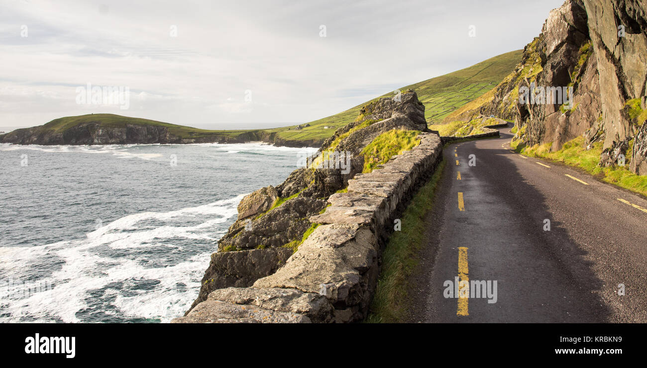 A spectacular narrow road winds along the cliffs of Slea Head on the Dingle Peninsula in the west of Ireland's County Kerry. Stock Photo
