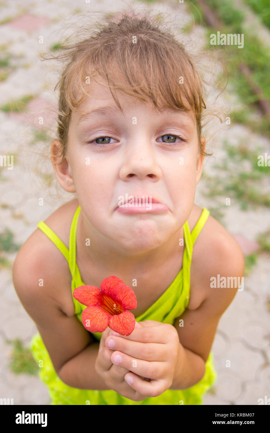 Funny girl with a flower in her hand crouched begging a face looking to