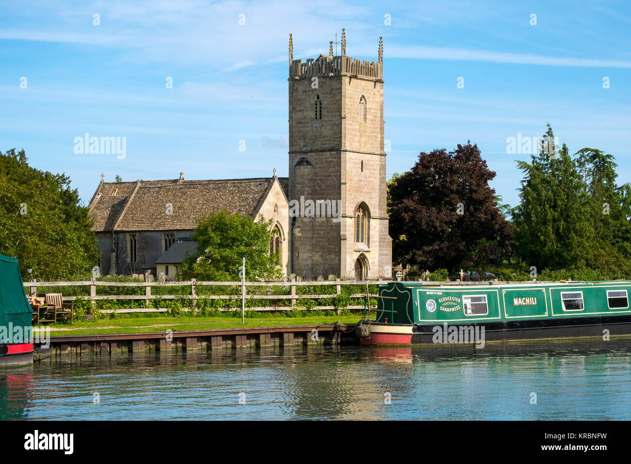 Spring sunshine on canal boats at peaceful moorings near St Marys Church on the Gloucester & Sharpness Canal at Frampton on Severn, Gloucestershire, UK Stock Photo