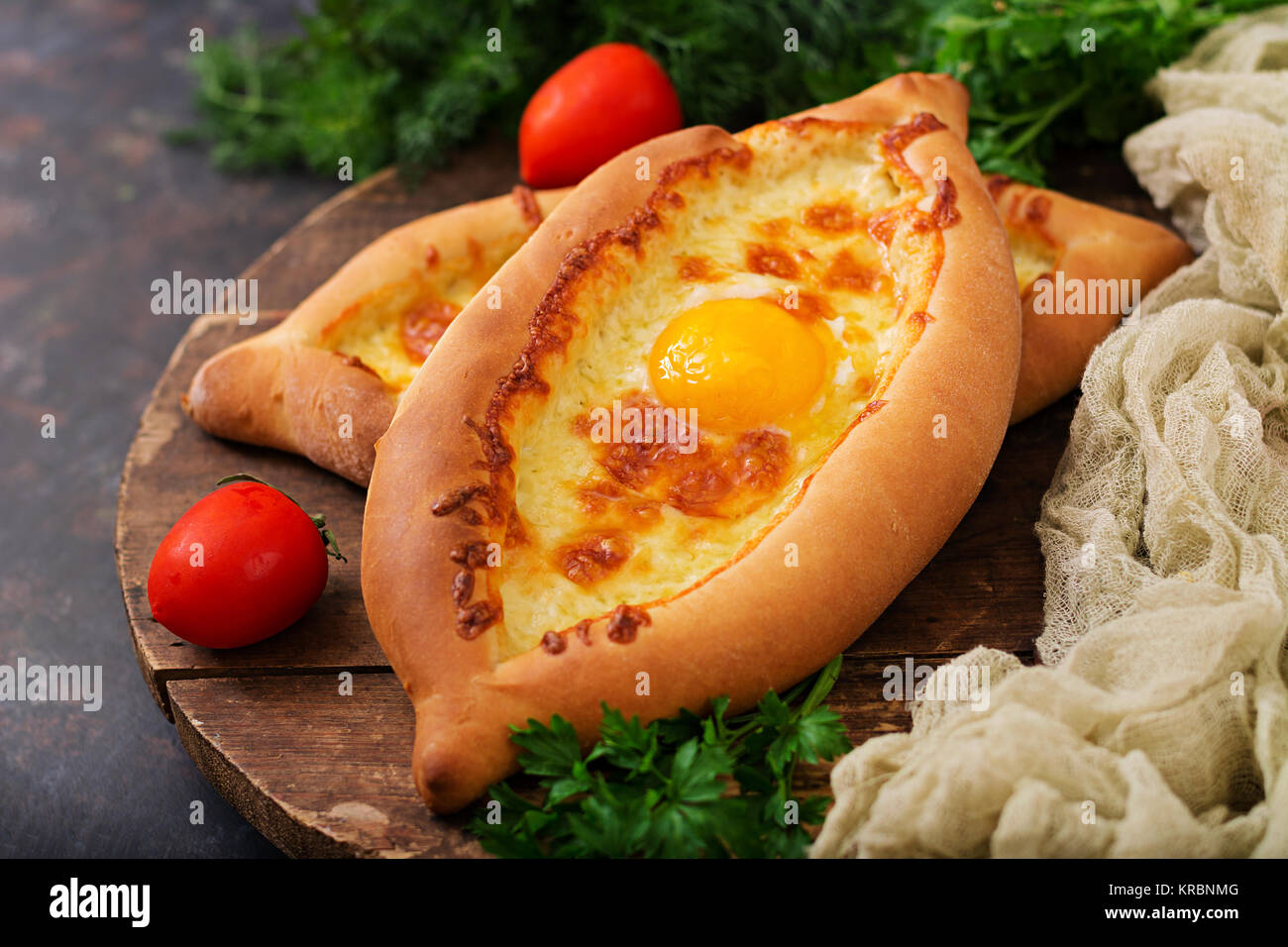 Khachapuri in Adjarian. Open pie with mozzarella and egg. Georgian cuisine. Stock Photo