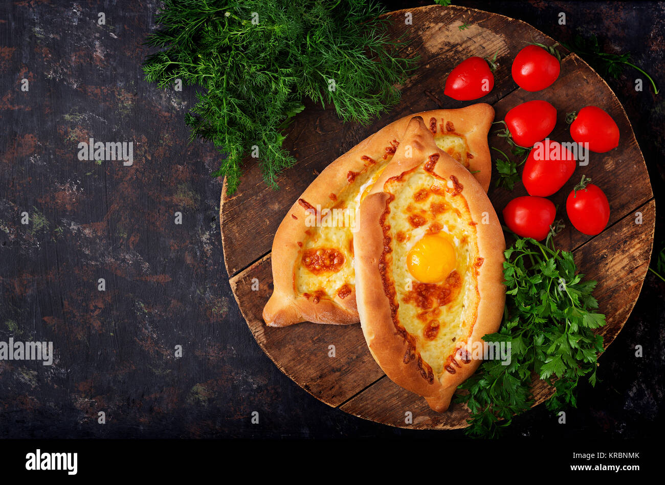 Khachapuri in Adjarian. Open pie with mozzarella and egg. Georgian cuisine. Stock Photo