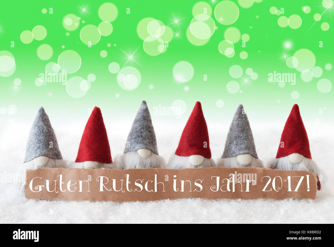 Label With German Text Guten Rutsch Ins Jahr 2017 Means Happy New Year 2017. Christmas Greeting Card With Gnomes. Sparkling Bokeh And Green Background With Snow And Stars. Stock Photo