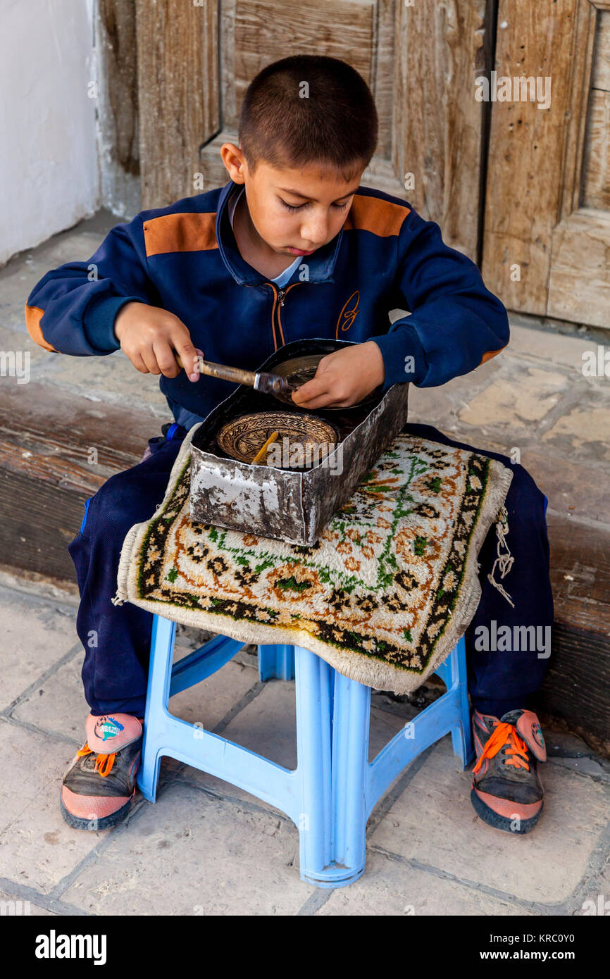 A Young Boy Engraving A Metal Plate At The Ark Fortress, Bukhara, Uzbekistan Stock Photo