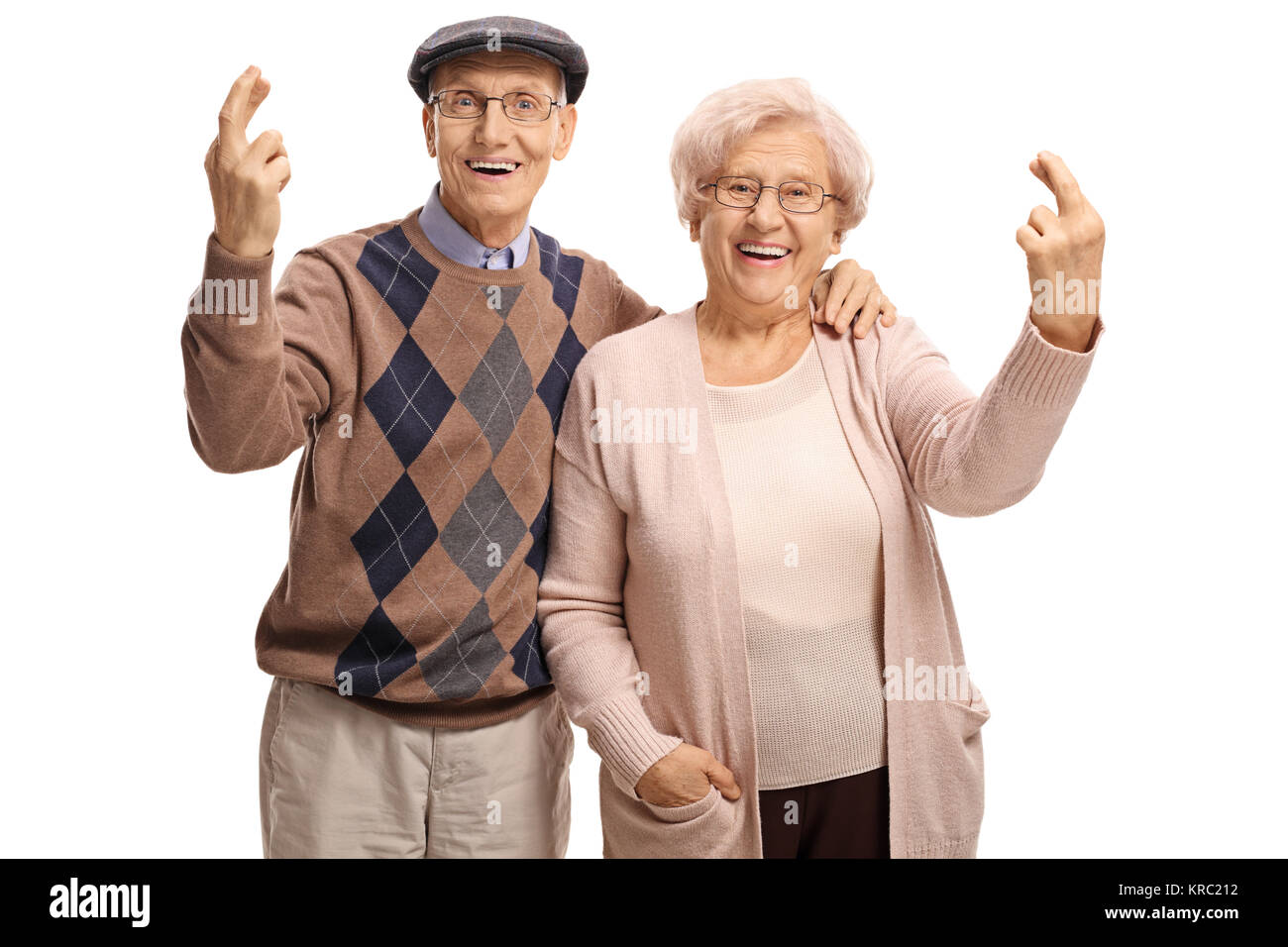 Elderly couple holding their fingers crossed isolated on white background Stock Photo