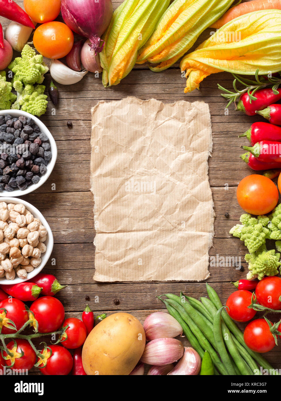 Vegetables, paper and chickpea on a wooden table Stock Photo