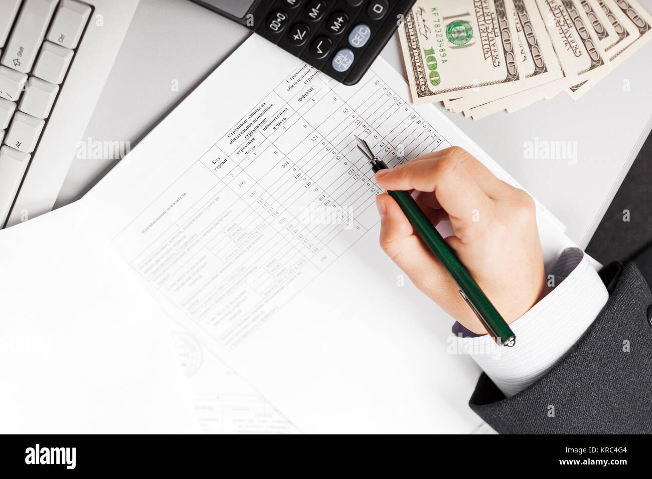 Working business man hand holding pen writing paper document at office ...