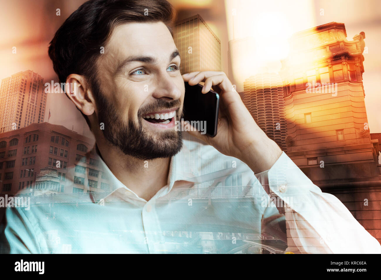 Surprised young man listening to good news on the phone Stock Photo