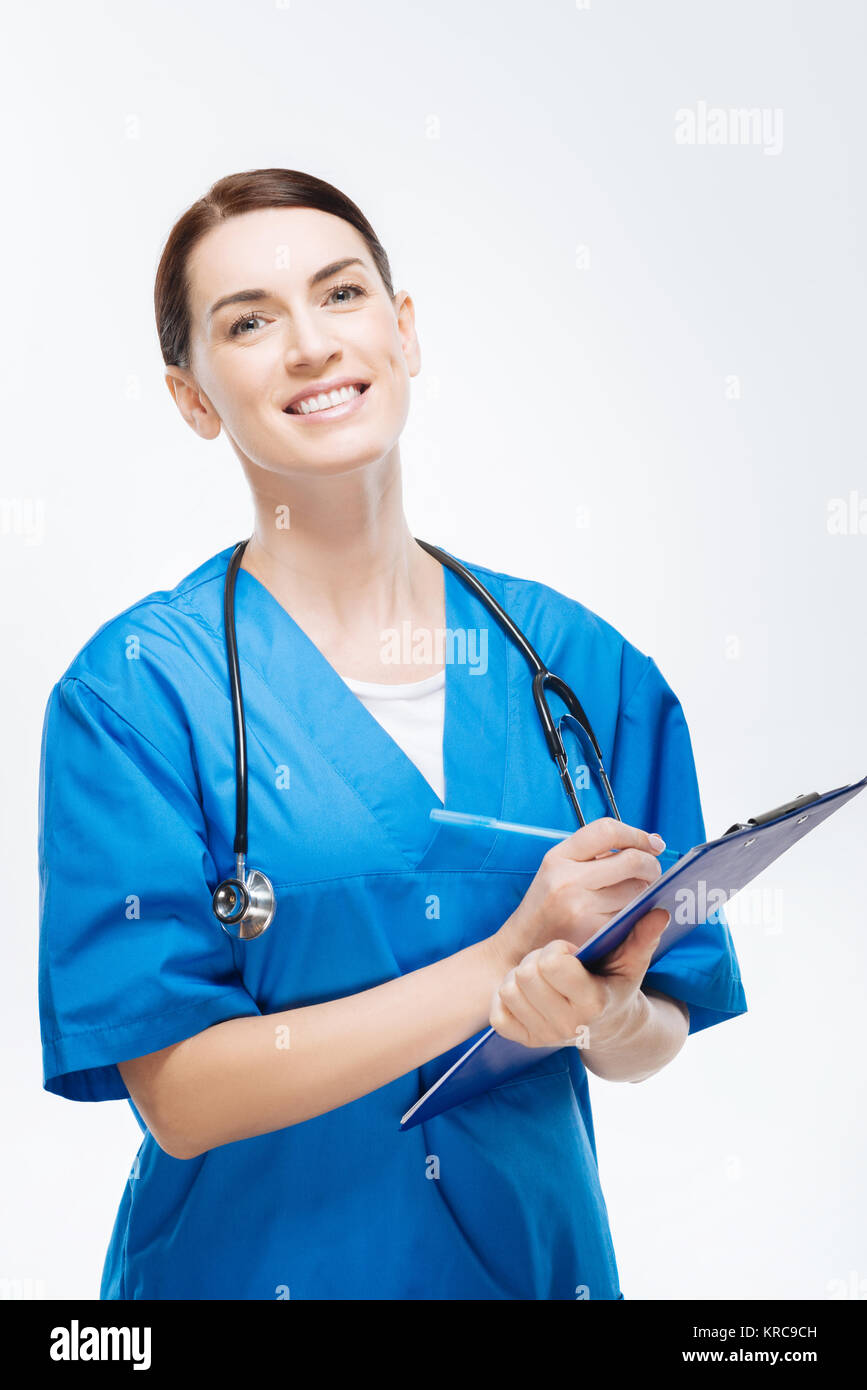 Pleasant female physician writing down patients history Stock Photo - Alamy