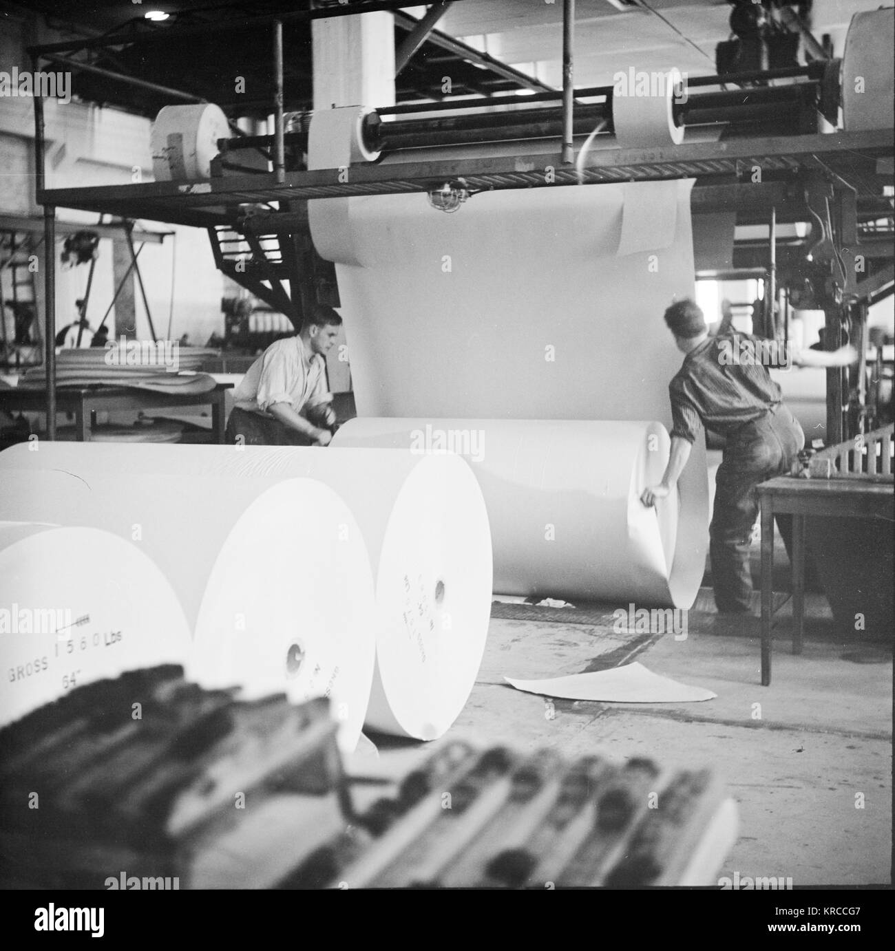Two male employees moving the finished paper roll, Summa paper mill
