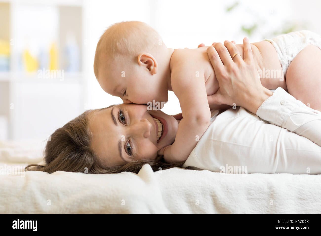 Adorable baby kissing his mother Stock Photo