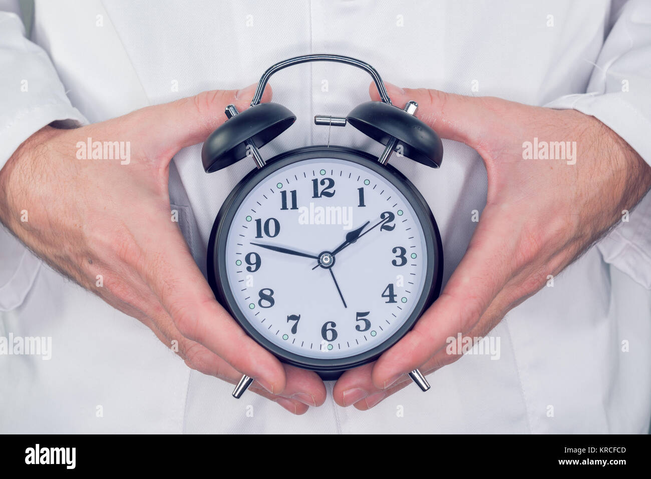 Doctor with alarm clock in hands, it is time to make an appointment for