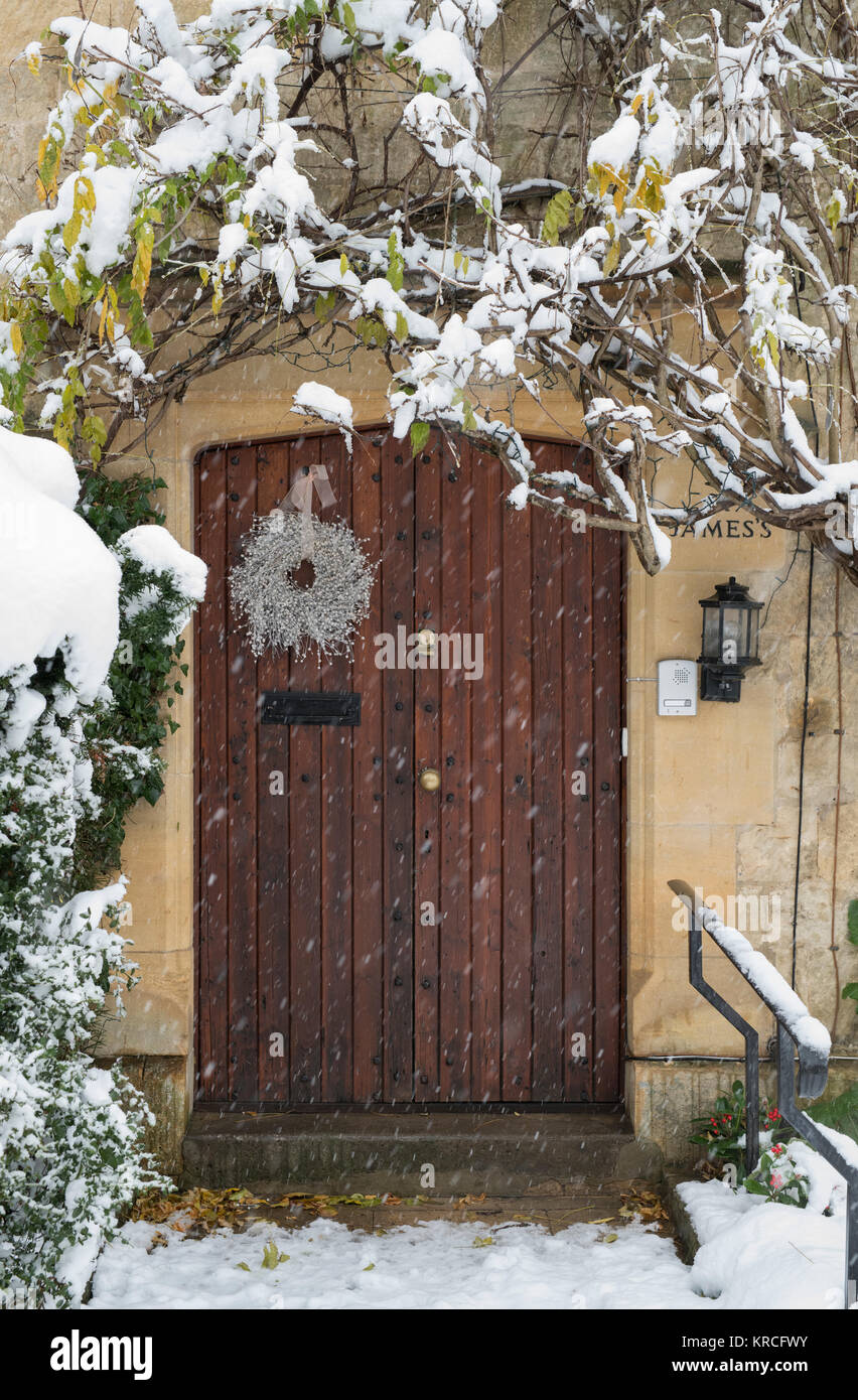 Christmas wreath on a cotswold stone house wooden front door in