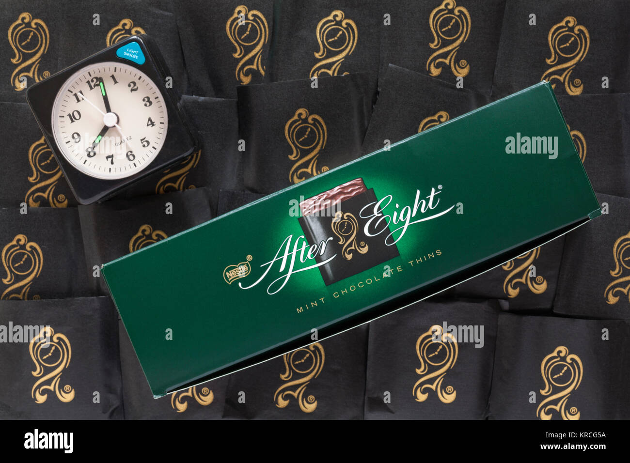 After Eight mint chocolate thins chocolates with alarm clock showing time as just past eight o'clock Stock Photo