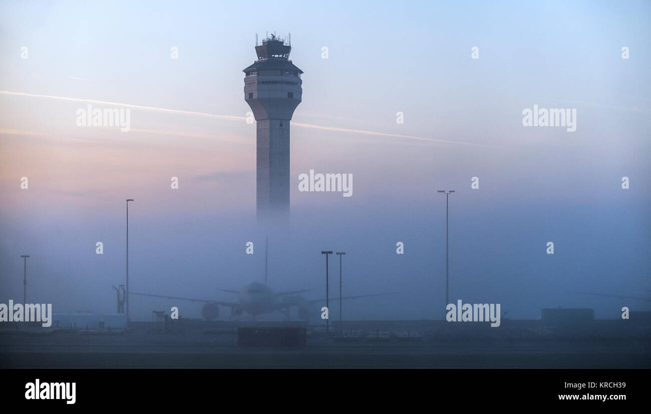 Dulles airport control tower, a single airplane, no people visible, a foggy early morning pink and blue sky. Loudoun & Fairfax county, Virginia, USA. Stock Photo