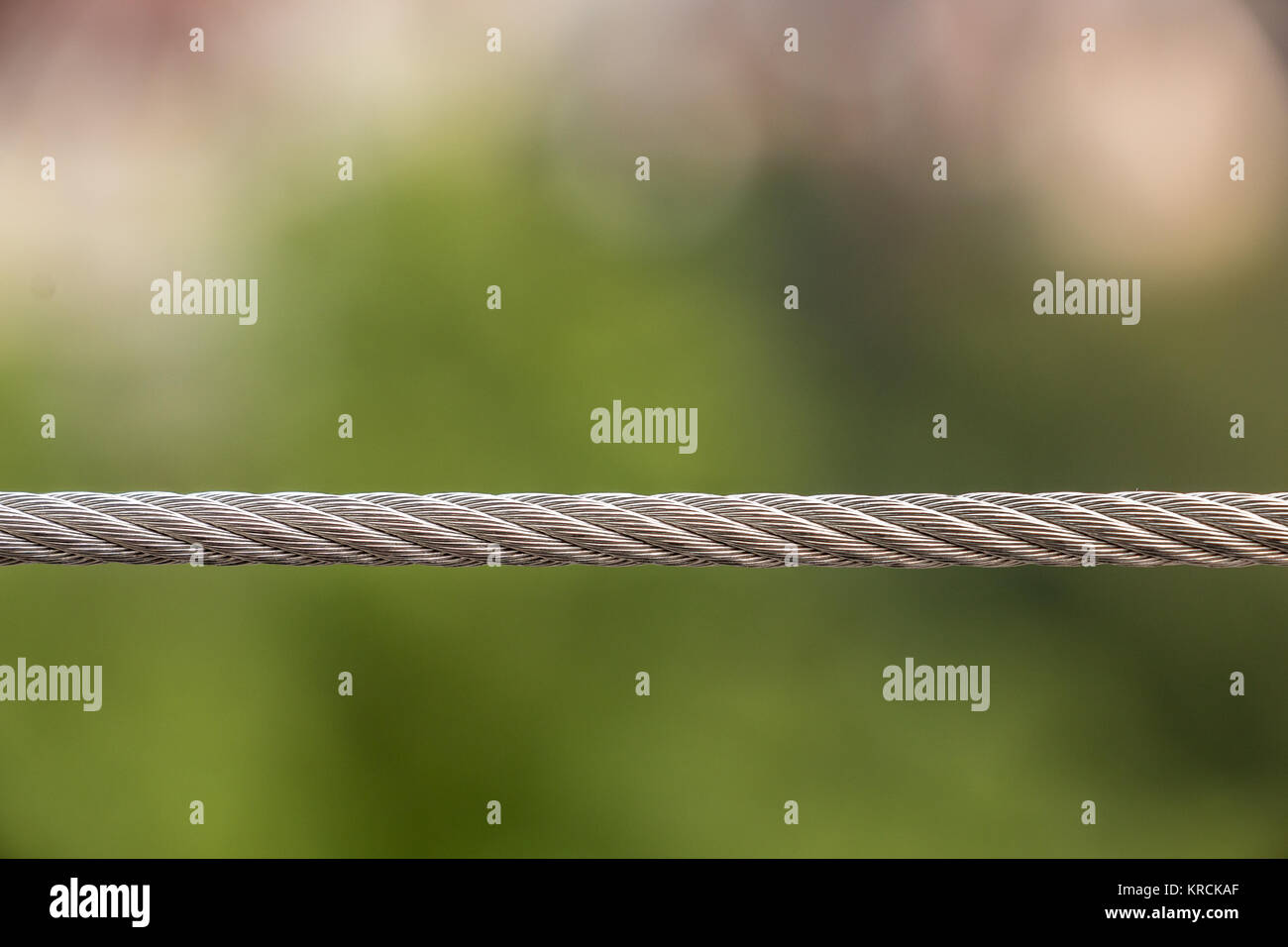 Strong steel cable and green blurred background Stock Photo