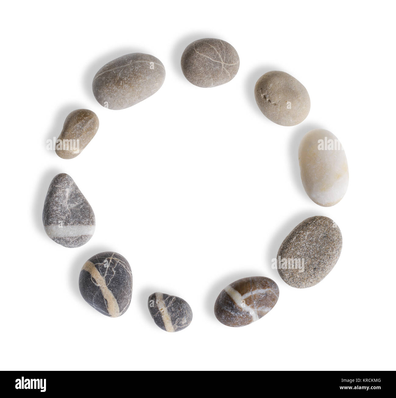 circular arrangement with small pebbles in white back with shadow seen from above Stock Photo