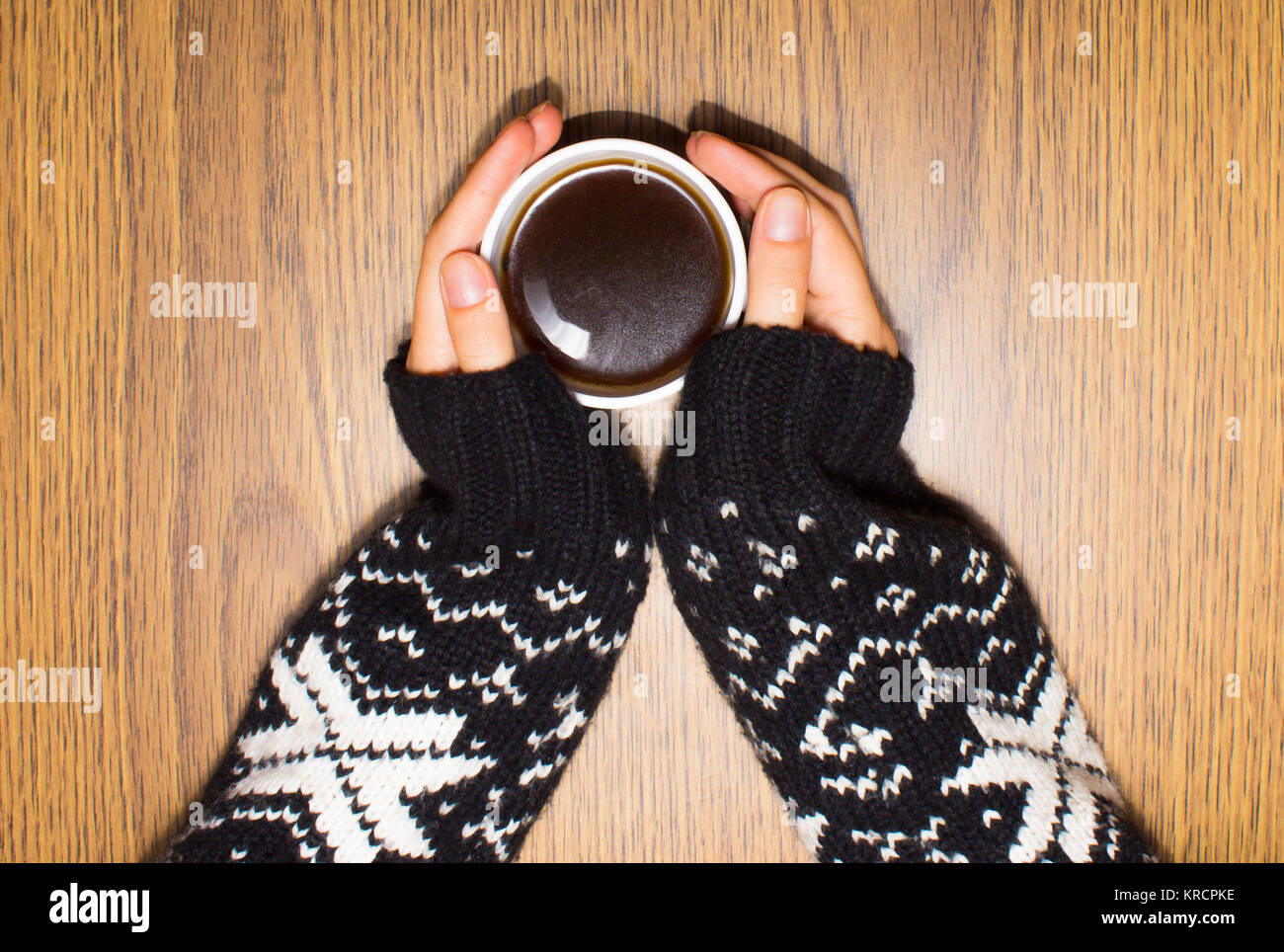 Woman hands in woolen sweater holding cup of coffee Stock Photo - Alamy