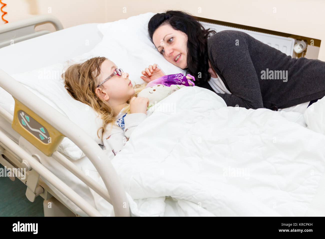 Mother care, worry about her sick daughter on hospital bed with her ...