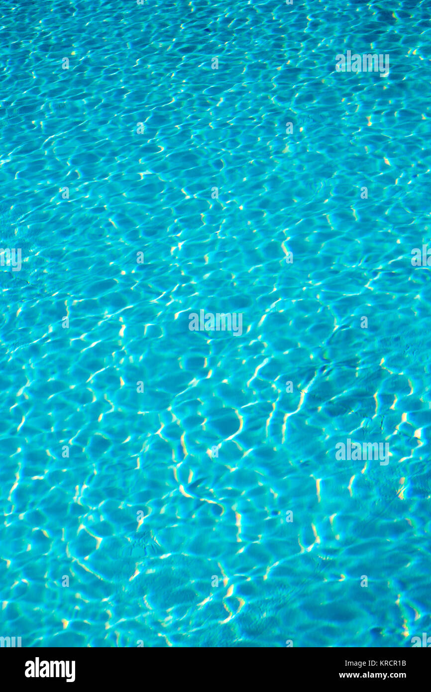 Textured light effect on the surface ripples of a blue outdoor swimming pool. Full frame background texture. Stock Photo