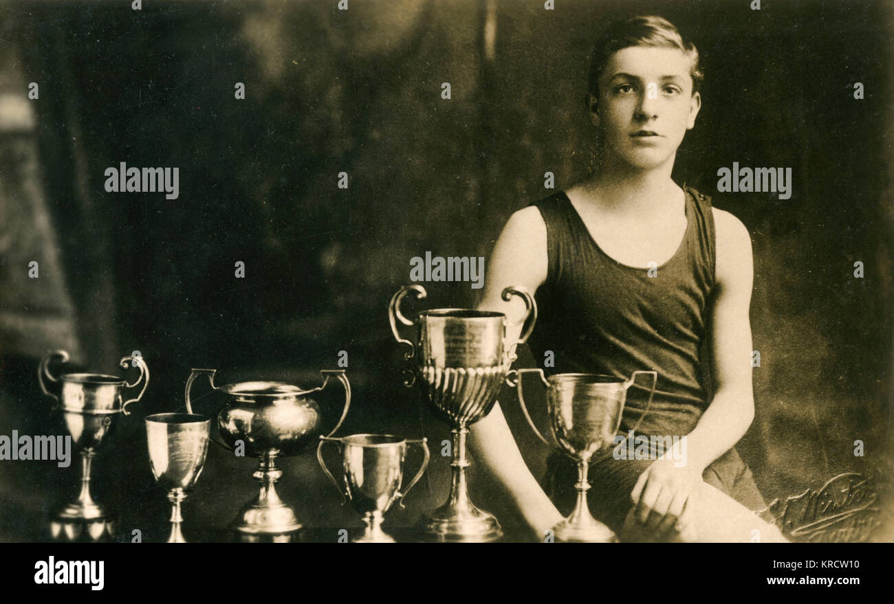 A 14-year-old swimming champion poses with the six trophies he has won. (1 of 2) Date: 1924 Stock Photo