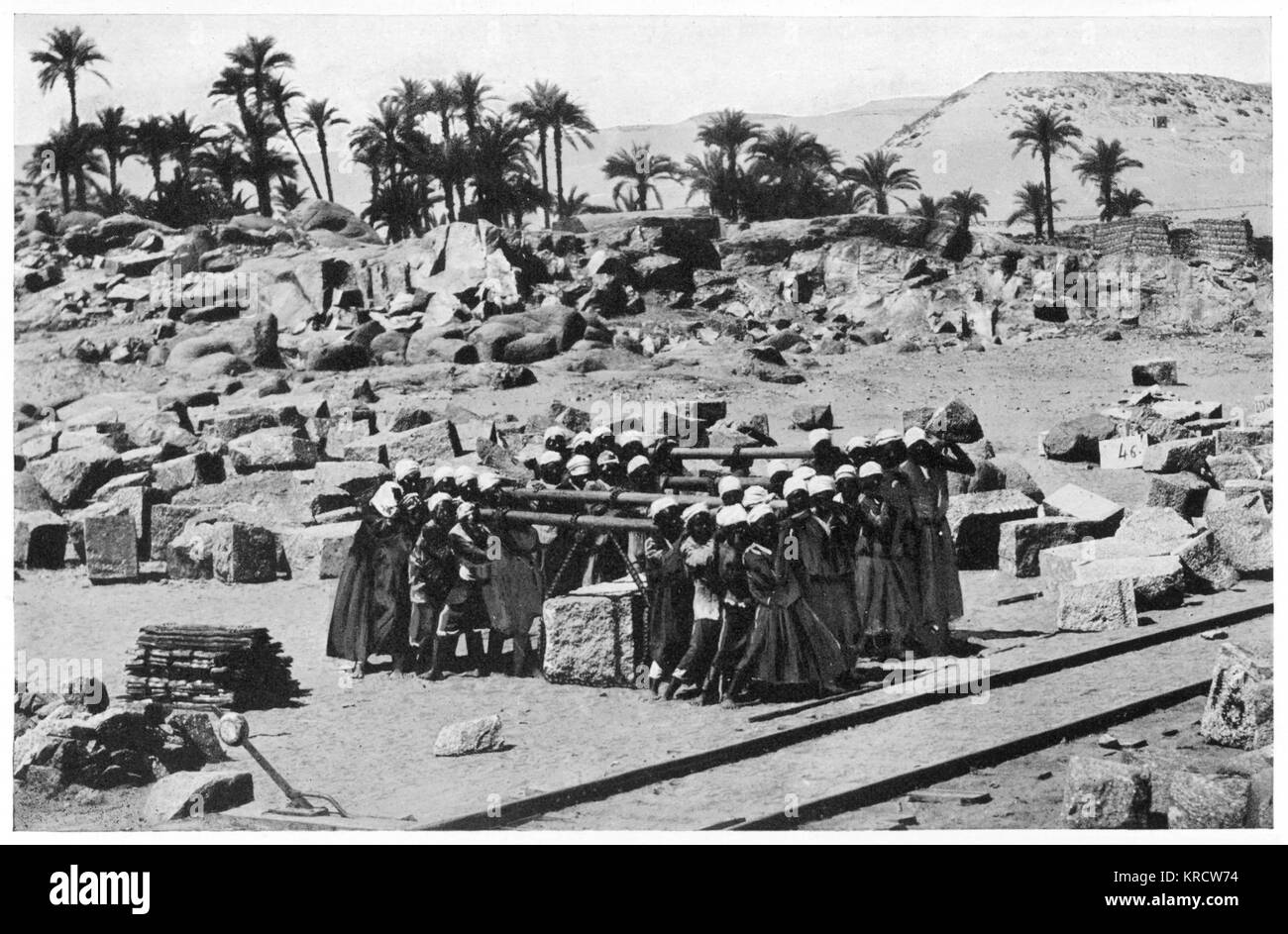 NILE DAM Stone porters transporting a granite lintel weighing three tons to be used in the construction of the Nile dam. Date: Circa 1900 Stock Photo