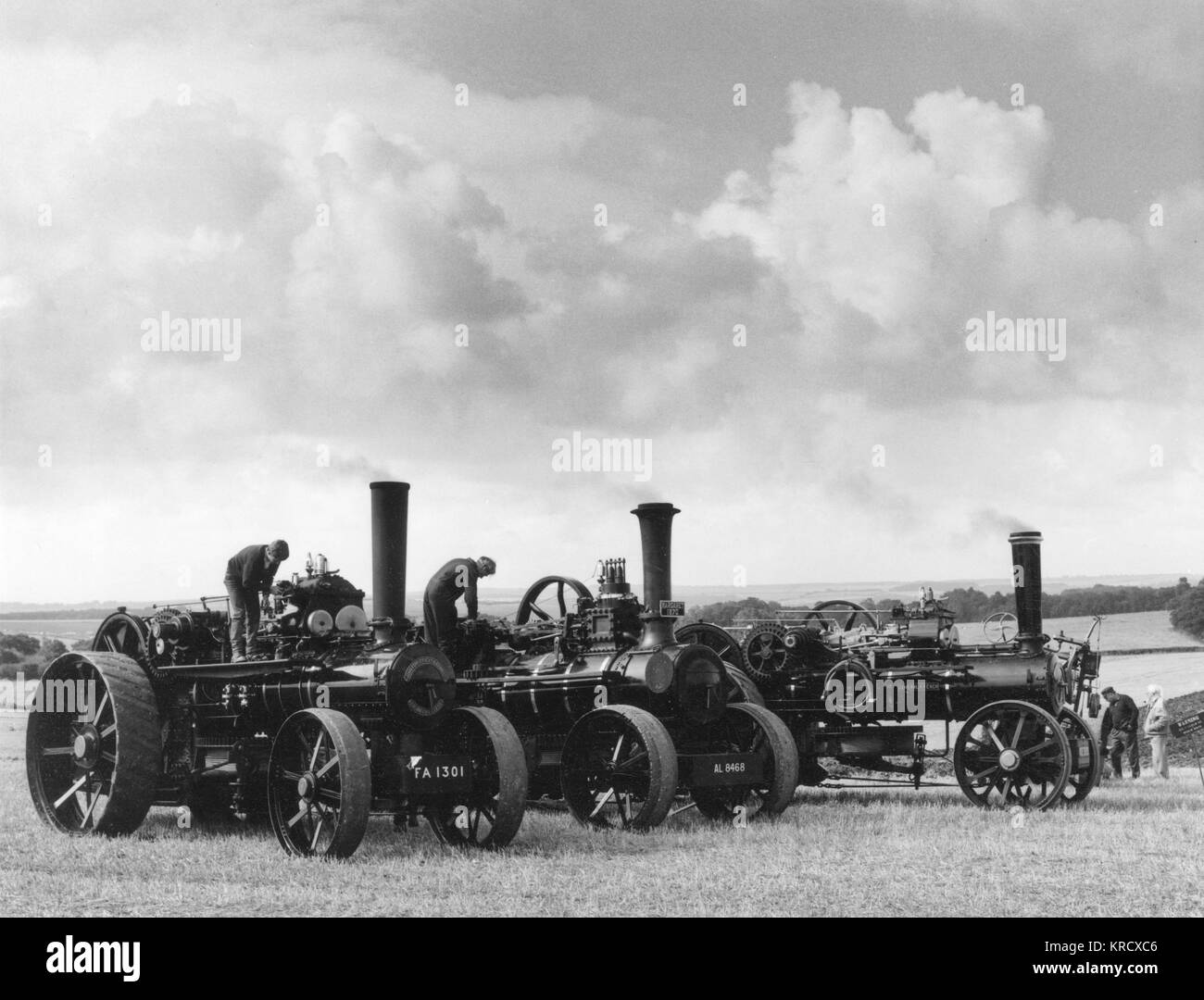 Enthusiasts gather around  three 19th century steam  ploughing engines at the Great  Steam Rally at Stourpaine,  Dorset, England.      Date: 1960s Stock Photo