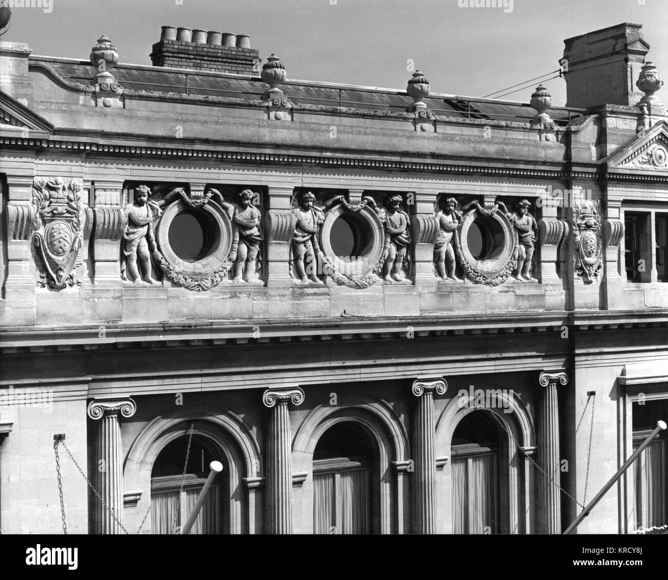 A Neo Classical frieze on the  facade of Gloucester  Guildhall, Gloucestershire,  England, decorated with  Ionic fluted columns and  cherubs bearing wreaths.     Date: built 1890s Stock Photo
