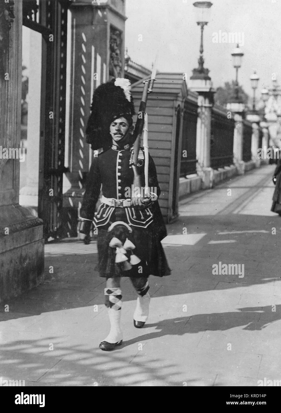 A Highland Guard on duty at Buckingham Palace -- the first time a kilted regiment had done duty at the Palace, the regular Guards being away on manoeuvres.     Date: circa 1910 Stock Photo