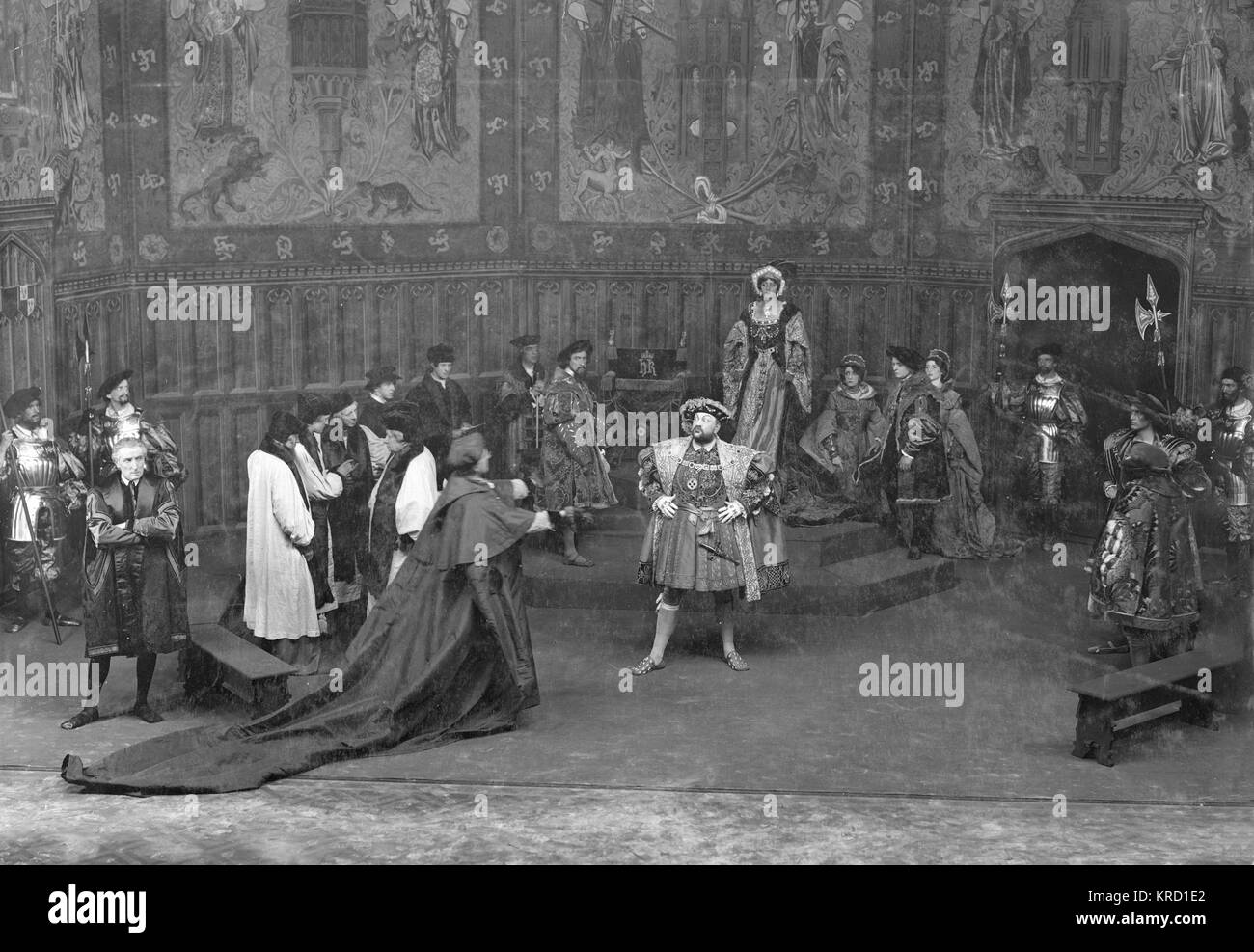 A scene from Shakespeare's play, Henry VIII, in a production by Herbert Beerbohm Tree at His Majesty's Theatre, London.  The production opened in 1910, was revived for the London Shakespeare Festival in 1911, and was repeated again in 1912.  Tree played Cardinal Wolsey.  Other actors were Violet Vanbrugh (Queen Katherine), Arthur Bourchier (King Henry) and Laura Cowie (Anne Bullen).  This scene shows a confrontation between Henry and Wolsey, while members of the court look on, concerned.   (3 of 6)     Date: circa 1910-1912 Stock Photo